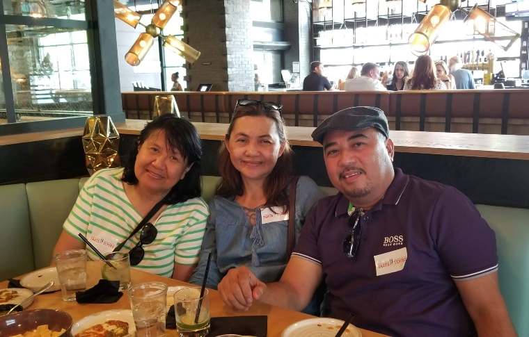 3 people sitting in a restaurant and smiling to the camera